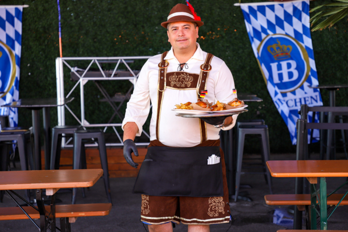 Man showcasing food & beer at OktoberFest NYC 2022 at Watermark