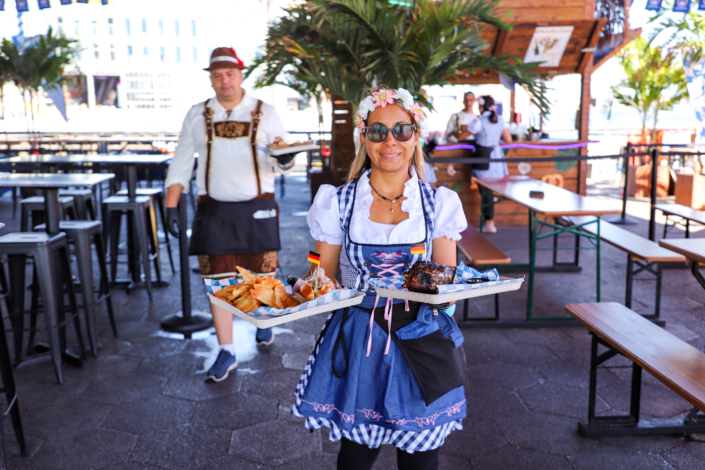 Girl showcasing food & beer at OktoberFest NYC 2022 at Watermark