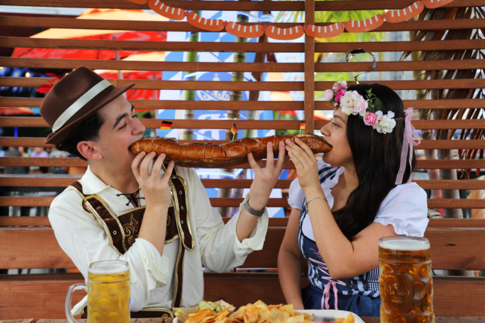 OktoberFest NYC Food - Couple Eating The Bratwurst Sandwich Platter