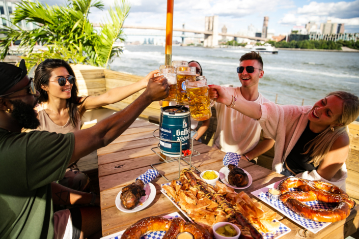 Friends Toasting with Beer and enjoying food at OktoberFest NYC 2021